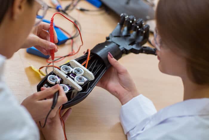 Engineers fixing a robot hand